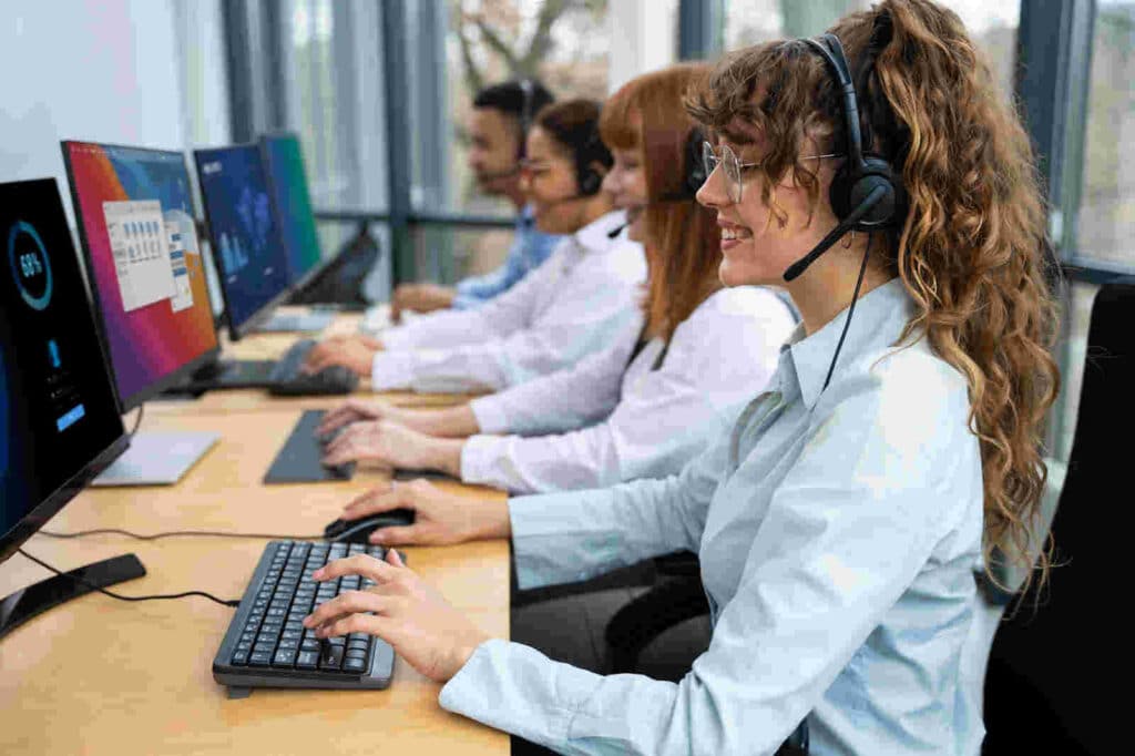 Profissional de atendimento utilizando computador e headset durante contato com consumidores em uma central de relacionamento.3.jpg